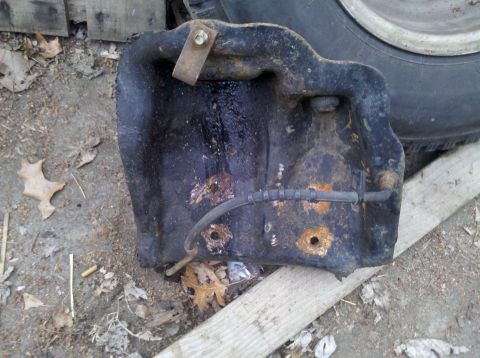 2003 Ford F-250 - A dirty, rusted metal component with a hose is visible, possibly a vehicle part.