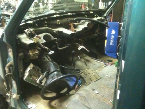1993 Ford Bronco - The interior of a vehicle is shown in a state of disassembly, with the dashboard and steering column exposed.