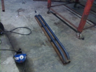 1995 Ford Bronco - Pair of tubular rock sliders shown in a workshop setting.