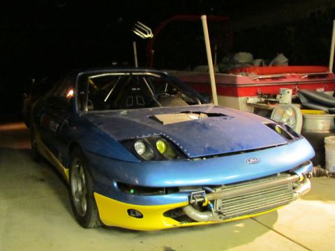 1995 Ford Probe - A modified 1995 Ford Probe with a custom front end and roll cage is parked indoors.
