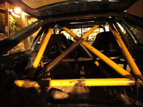 1995 Ford Probe - Custom yellow roll cage installed inside a car's interior, with racing seats visible.