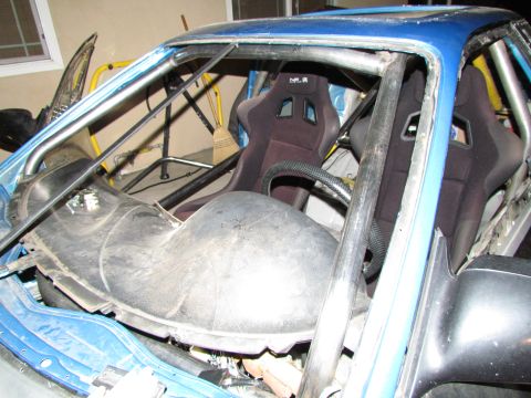 1995 Ford Probe - This modified car features racing seats and a prominent roll cage, suggesting it's built for performance.