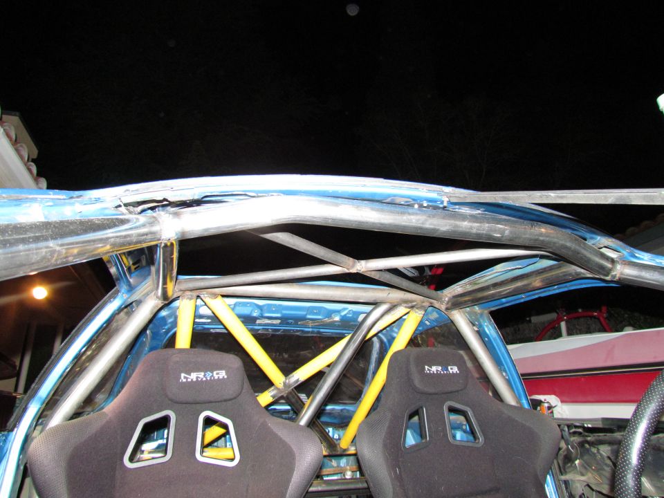 Interior of a blue car with black racing seats and a metal roll cage