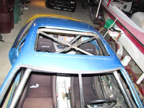 1995 Ford Probe - Interior view of a blue car with a roll cage and racing seats, "DR" branding on the seats.