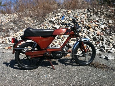 1981 Garelli Rally Sport - A red Garelli moped is parked outdoors against a backdrop of rubble and dry brush.