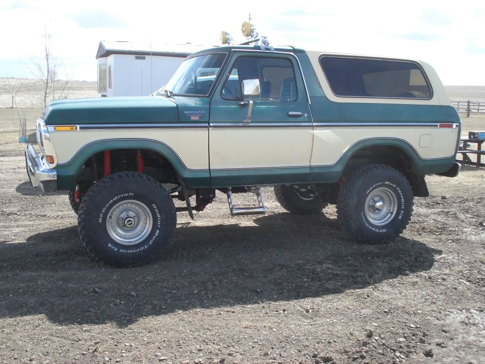 1979 Ford Bronco lifted with off-road tires, two-tone green and cream paint