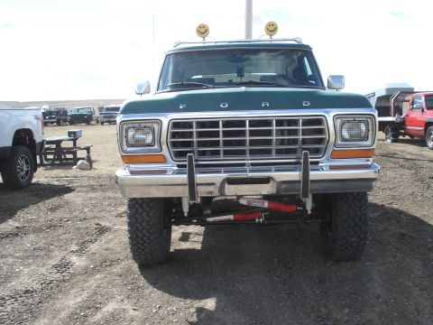 1979 Ford Bronco - A green 1978 Ford Bronco is parked outdoors with other vehicles visible in the background.