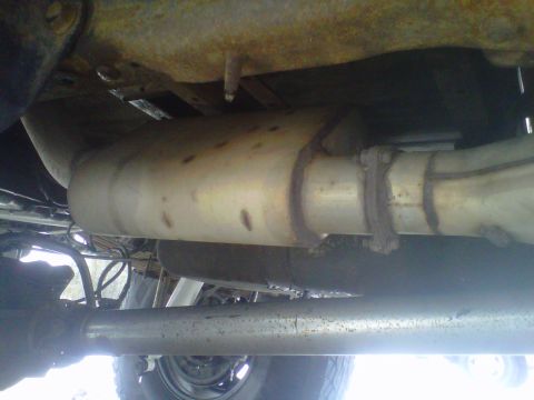 1994 Ford F-150 - The underbody exhaust system of a 1994 Ford F-150 pickup truck is visible in this photograph.
