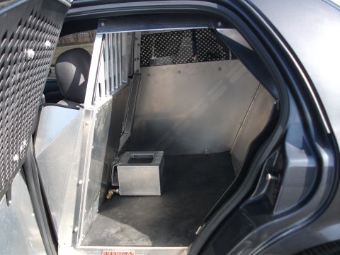 2001 Ford Crown Victoria - View inside a police vehicle showing the custom partition and cage installed in the rear compartment.
