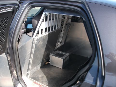 2001 Ford Crown Victoria - Rear interior of a police vehicle modified with a partition and cage system.