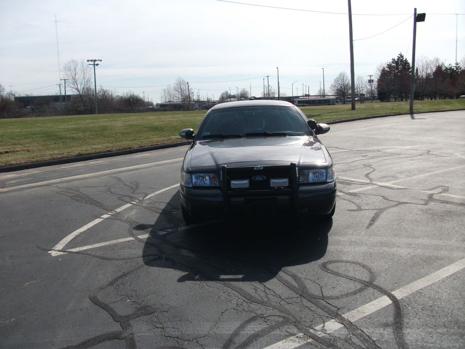 Front view of a dark 2001 Ford Crown Victoria with a push bar