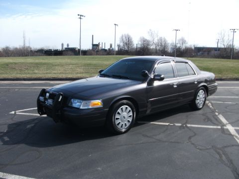 2001 Ford Crown Victoria - 2001 Ford Crown Victoria police car with push bumper parked outdoors.