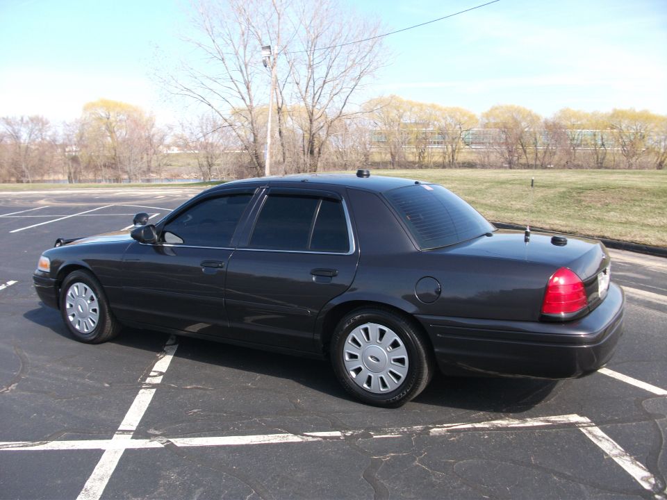 Dark gray sedan parked in a lot, viewed from the rear quarter angle