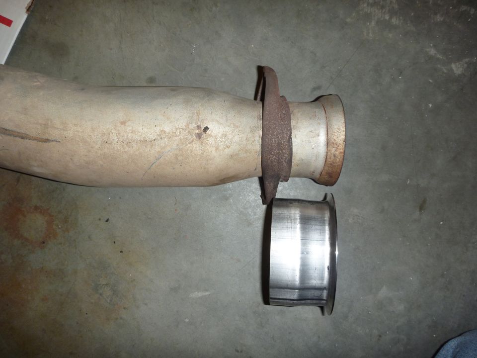 Exhaust pipe with flange and separate metal ring on concrete floor