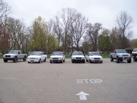 1987 Ford Ranger - Several Ford Ranger pickup trucks are parked in a lot under a cloudy sky.