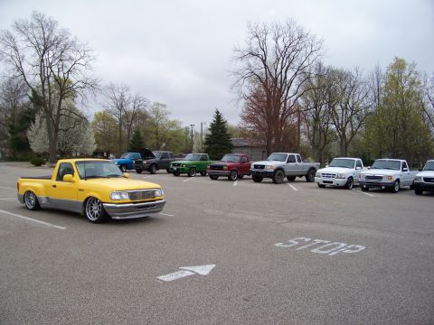 1987 Ford Ranger - A group of Ford Ranger pickup trucks are parked in a lot on a cloudy day.