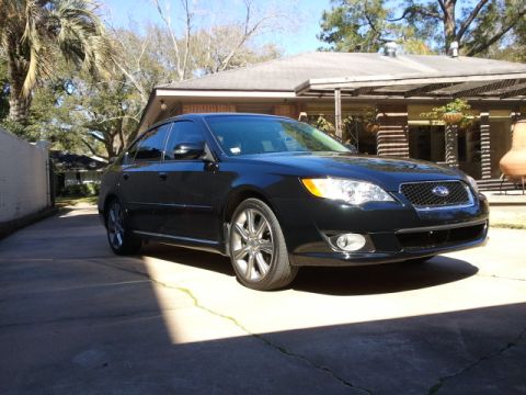 2008 Subaru Legacy - A black 2008 Subaru Legacy sedan is parked in a driveway on a sunny day.