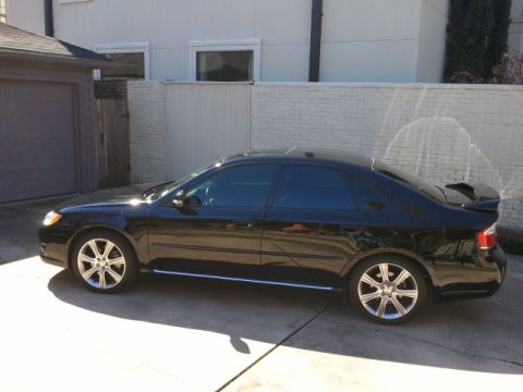 2008 Subaru Legacy - Side profile of a black sedan with tinted windows and a rear spoiler.