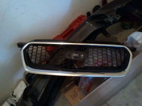 2008 Subaru Legacy - A car grille with a honeycomb pattern and a Ford emblem is shown, likely a replacement part.