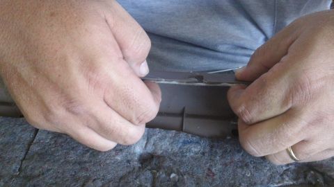 1994 Ford Bronco - Close-up of hands removing a piece of interior trim, with a Supermotors.net watermark.