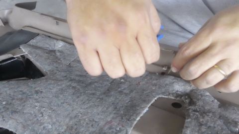 1994 Ford Bronco - Hands are seen working on the interior of a vehicle, likely removing a door panel for repair.