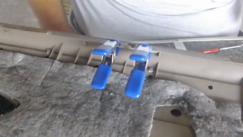1994 Ford Bronco - Clamps are used to hold a car's interior door panel in place during repair work.