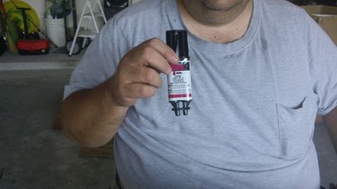 1994 Ford Bronco - A person holds a tube of JB Weld adhesive, a product often used for vehicle repairs.