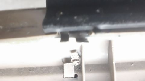 1994 Ford Bronco - Close-up of a broken plastic clip on a car's interior door panel.