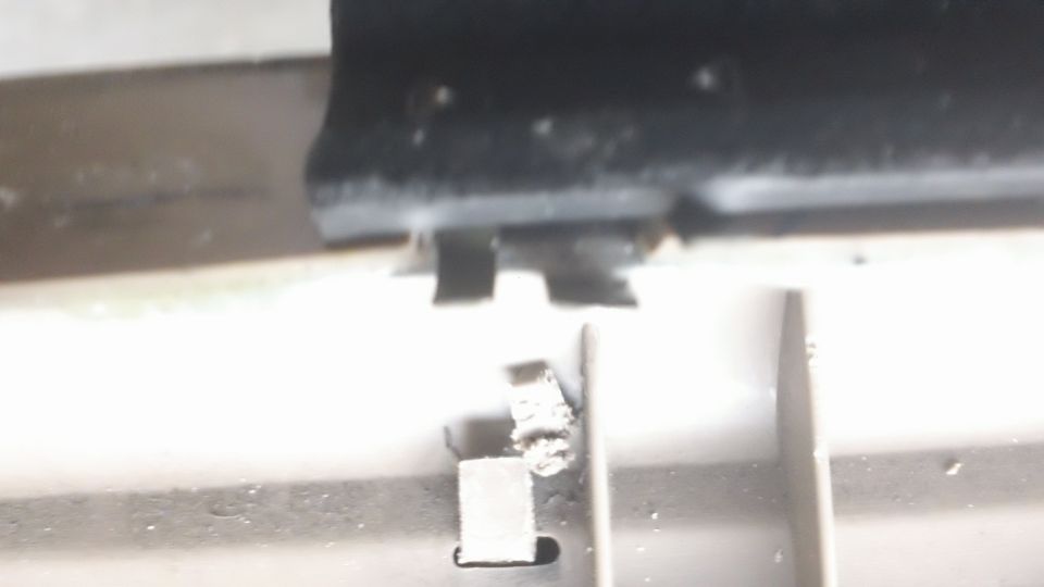 Broken plastic clip on interior car door panel, possibly from a Ford Bronco