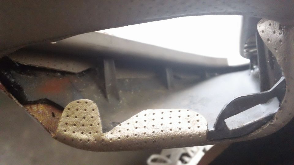 Close-up of a perforated interior door panel with some metal bracing visible