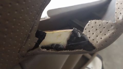 1994 Ford Bronco - A damaged car door panel reveals its internal construction and foam padding.