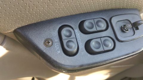 1994 Ford Bronco - Close-up of the driver's side door controls, showing window and lock buttons.