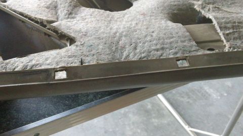 1994 Ford Bronco - Close-up of a car's interior door panel, showing the underlying structure and insulation material.