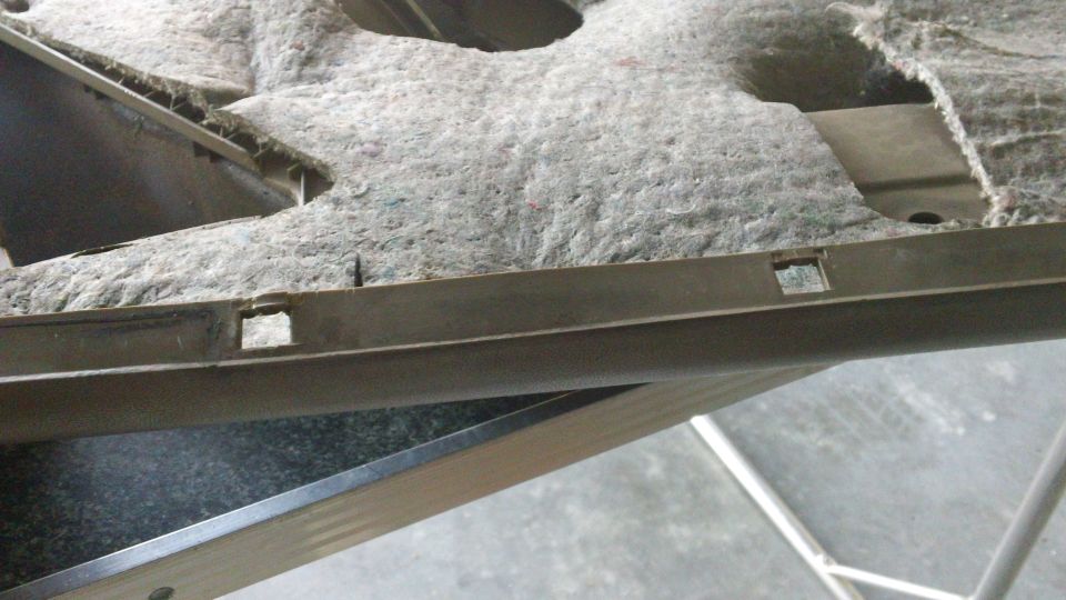 Car door panel interior with gray fabric and plastic trim. Visible clips and cutouts