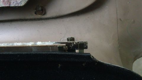 1994 Ford Bronco - This image shows a close-up view of a door panel repair, highlighting the hardware and adhesive used in the process.