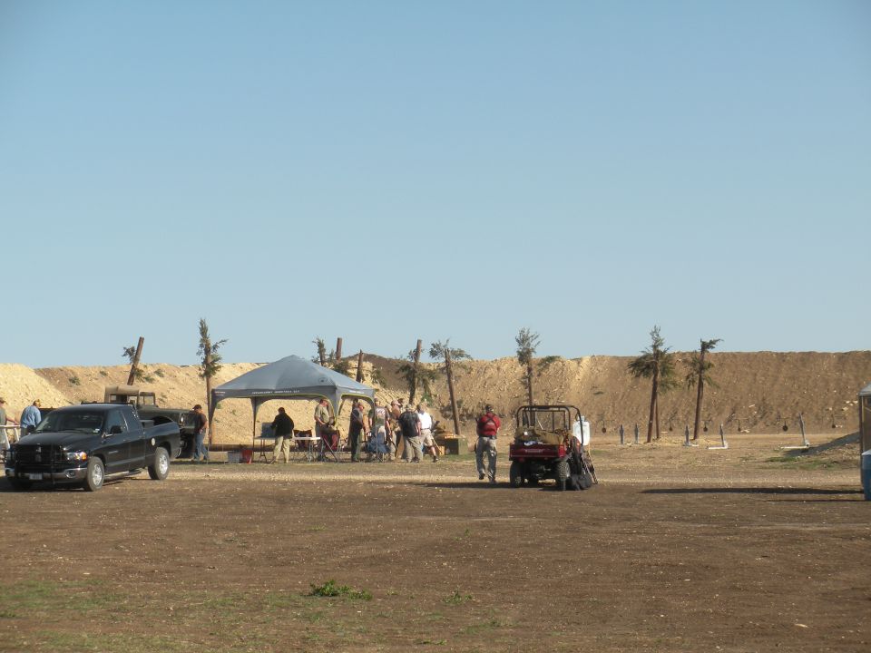 Black pickup truck and red utility vehicle at an outdoor gathering
