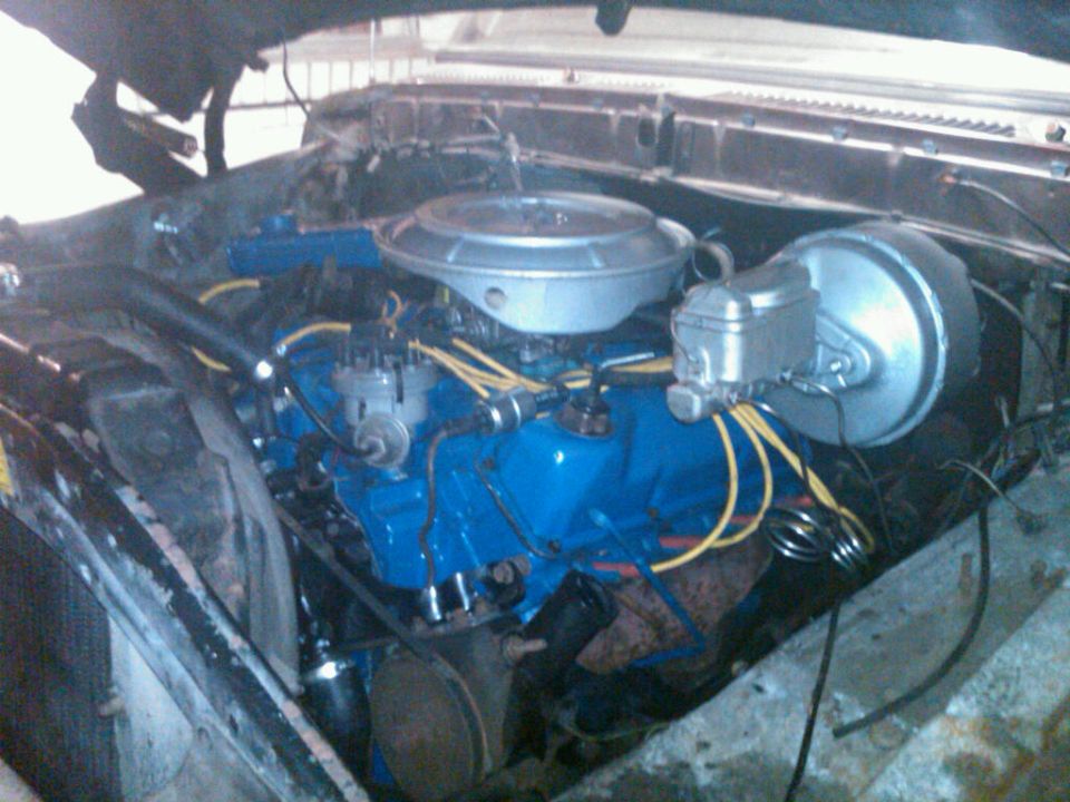 engine bay with blue painted engine block, air cleaner, and brake booster