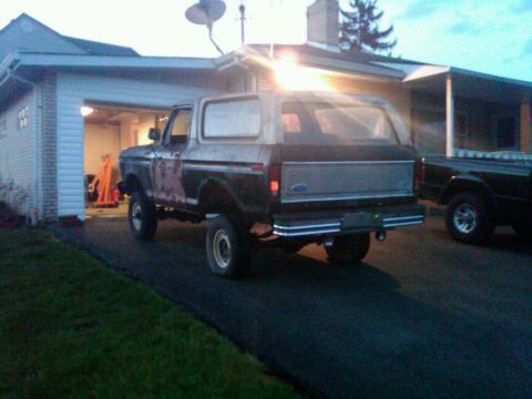 1979 Ford Bronco - A two-tone Ford Bronco is parked on a driveway next to another vehicle.