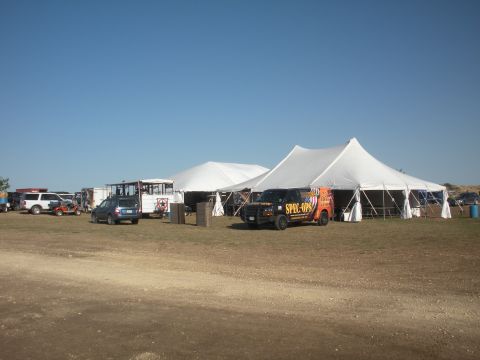1996 Ford Bronco - A collection of vehicles, including a van with 'SPEC-OPS' branding, are situated outdoors near large white tents.