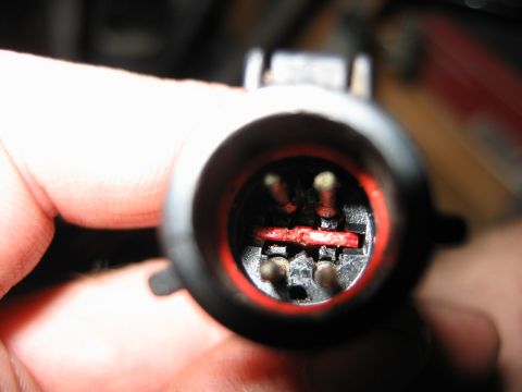 1992 Ford Bronco - This is a close-up view of an electrical connector, showing its internal pins and a red retainer.