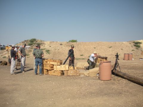 1996 Ford Bronco - A group of people are gathered at a shooting range, with some aiming firearms and others observing.