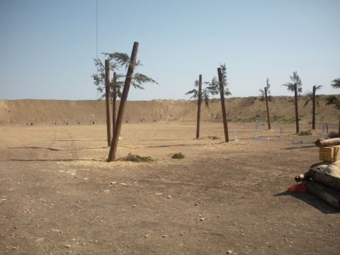 1996 Ford Bronco - An outdoor shooting range is set up with targets and wooden posts under a clear blue sky.