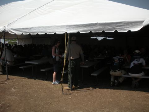 1996 Ford Bronco - A large gathering of people are seated at picnic tables under a white tent, with some individuals standing near the entrance.