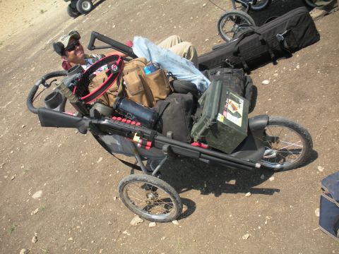 1996 Ford Bronco - A person sits in a modified stroller loaded with firearms and equipment.