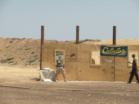 1996 Ford Bronco - A shooter practices at a range with a Cabela's banner visible on the plywood structure.
