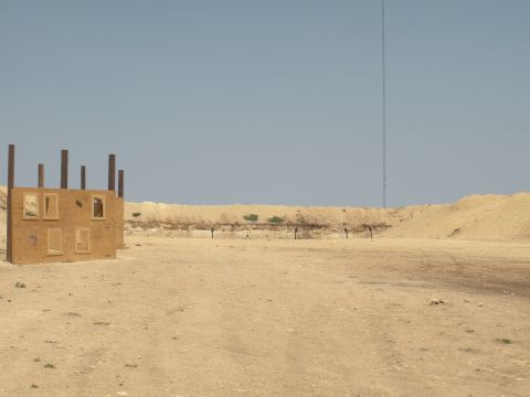 1996 Ford Bronco - A desolate landscape features a makeshift structure and targets, suggesting a location for shooting practice.