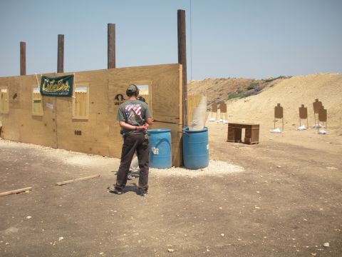 1996 Ford Bronco - A person stands at a shooting range, with targets and a wooden structure visible in the background.
