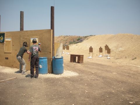 1996 Ford Bronco - Two individuals are practicing at an outdoor shooting range with various targets set up.