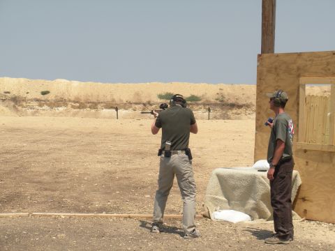 1996 Ford Bronco - Two men are at an outdoor shooting range on a sunny day, with one person aiming a rifle downrange.