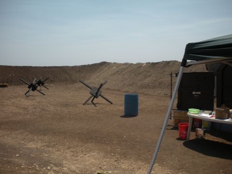 1996 Ford Bronco - A desolate outdoor scene features several anti-tank obstacles and a blue barrel under a clear sky.